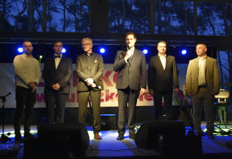 Zdjęcie przedstawia grupę mężczyzn na scenie.
